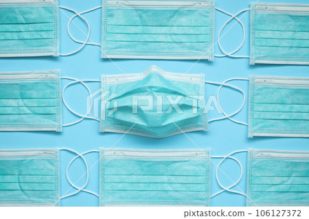 Surgical face mask on blue background protection against COVID-19 coronavirus. Healthcare and medical concept 106127372