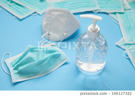 KN95 Medical face mask with alcohol sanitizer gel hand wash bottle on blue background covid-19 Coronavirus prevention concept KN95 Medical face mask with alcohol sanitizer gel hand wash bottle on blue background covid-19 Coronavirus prevention concept 106127382