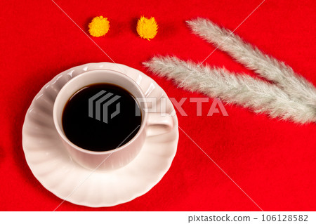 Coffee and chocolate placed on a red carpet with wintery dried flowers 106128582
