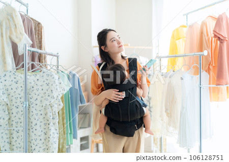 年輕父母和孩子在購物中心操作智能手機時購物 年輕父母和孩子在購物中心操作智能手機時購物 106128751