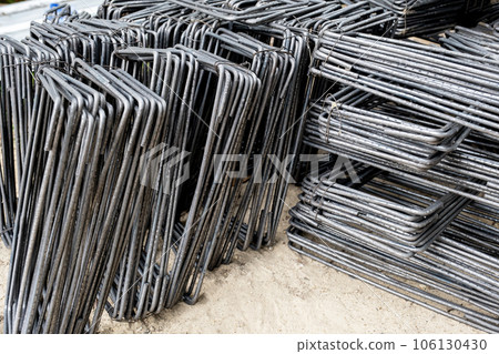 Steel bars piled up in front of construction site work 106130430