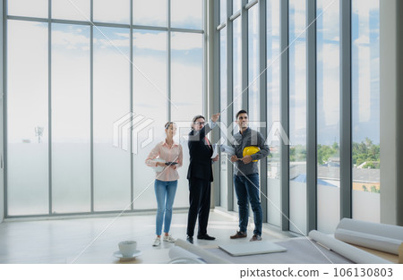 Engineer team meeting to inspect the construction blueprint drawings, work plan and distribute work before starting the building Engineer team meeting to inspect the construction blueprint drawings, work plan and distribute work before starting the building 106130803