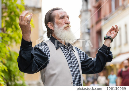Portrait of senior man praying with closed eyes to God asking for blessing help forgiveness outdoors Portrait of senior man praying with closed eyes to God asking for blessing help forgiveness outdoors 106130969