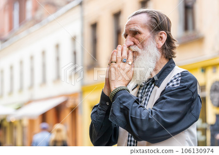 Portrait of senior man praying with closed eyes to God asking for blessing help forgiveness outdoors Portrait of senior man praying with closed eyes to God asking for blessing help forgiveness outdoors 106130974