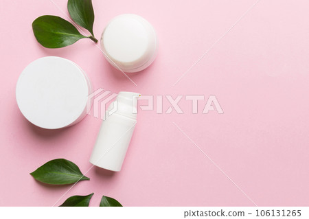 Organic cosmetic products with green leaves on color background. Copy space, flat lay 106131265