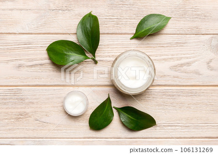 Organic cosmetic products with green leaves on wooden background. Flat lay 106131269
