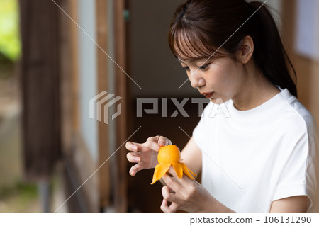Woman eating fruit on the porch Woman eating fruit on the porch 106131290