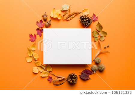 Autumn composition with paper blank and dried leaves on table. Flat lay, top view, copy space 106131323