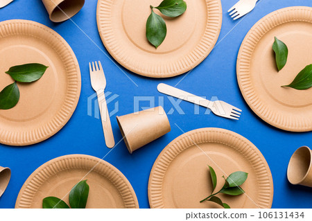 set of empty reusable disposable eco-friendly plates, cups, utensils on light white colored table background. top view. Biodegradable craft dishes. Recycling concept. Close-up 106131434