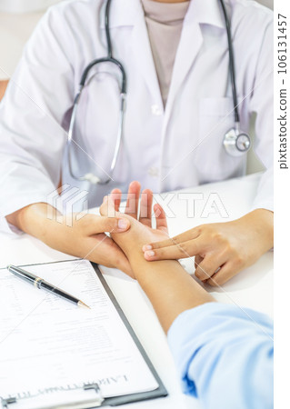 Doctor hand examines the patient's pulse and records the results, health medical checkup concept Doctor hand examines the patient's pulse and records the results, health medical checkup concept 106131457