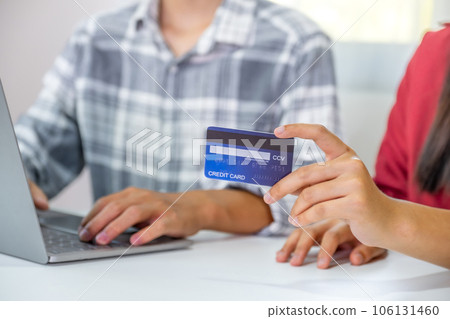 Young couple consumer hand holding mock up credit card, Ready to spend pay online shopping according to discount products via smartphone and laptop from home office Young couple consumer hand holding mock up credit card, Ready to spend pay online shopping according to discount products via smartphone and laptop from home office 106131460