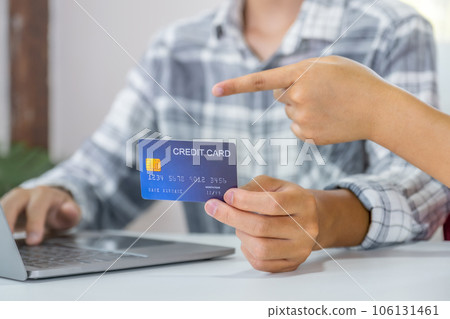 Young couple consumer hand holding mock up credit card, Ready to spend pay online shopping according to discount products via smartphone and laptop from home office Young couple consumer hand holding mock up credit card, Ready to spend pay online shopping according to discount products via smartphone and laptop from home office 106131461