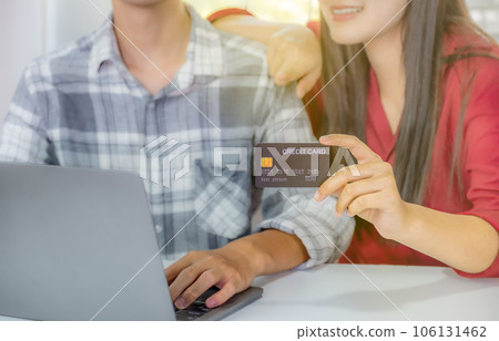 Young couple consumer hand holding mock up credit card, Ready to spend pay online shopping according to discount products via smartphone and laptop from home office Young couple consumer hand holding mock up credit card, Ready to spend pay online shopping according to discount products via smartphone and laptop from home office 106131462
