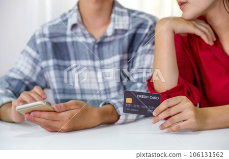 Young couple consumer hand holding mock up credit card, Ready to spend pay online shopping according to discount products via smartphone and laptop from home office Young couple consumer hand holding mock up credit card, Ready to spend pay online shopping according to discount products via smartphone and laptop from home office 106131562