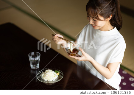 Cute woman eating somen noodles at home Cute woman eating somen noodles at home 106131586