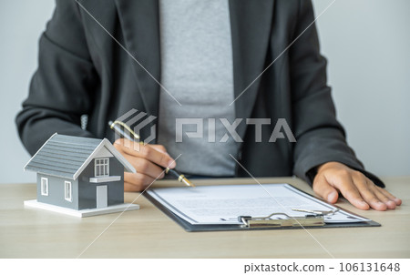 home model, real estate agent hand holding pen and explains the business contract, rent, purchase, mortgage, a loan, or insurance home model, real estate agent hand holding pen and explains the business contract, rent, purchase, mortgage, a loan, or insurance 106131648