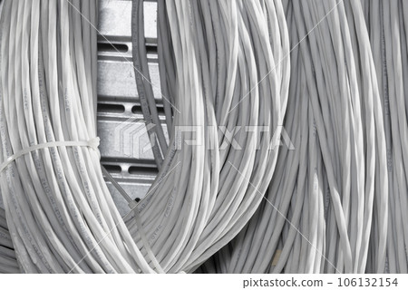detail of large number of ethernet cables tied together connecting racks inside server room 106132154
