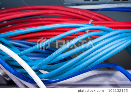bunch of patch network cables sorted in rack cabinet, leading from patch panel in the server rack in the data center room 106132155