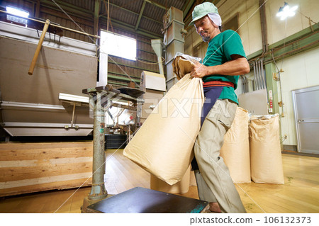 Male staff weighing tea leaves at a tea factory Male staff weighing tea leaves at a tea factory 106132373