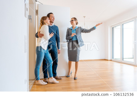 Realtor showing house to a young couple 106132536