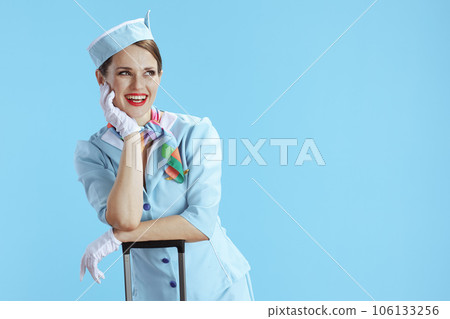 happy female flight attendant on blue looking at copy space 106133256
