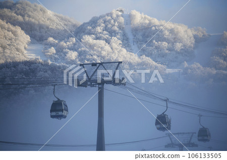 Gondolas and mountain slopes seen through a break in the mist 106133505
