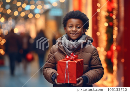 African American boy with a Christmas gift in mall. 106133710
