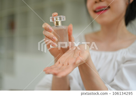 Smiling female beauty blogger with perfume recording video in dressing room. Blogging, makeup and lifestyle concept. 106134295