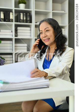 Attractive middle age businesswoman having nice conversation and looking aways 106134384