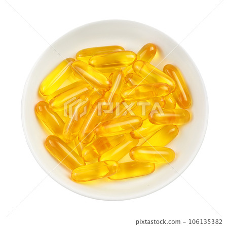 Fish oil capsules in bowl isolated on white background with clipping path and full depth of field. Top view. Flat lay 106135382