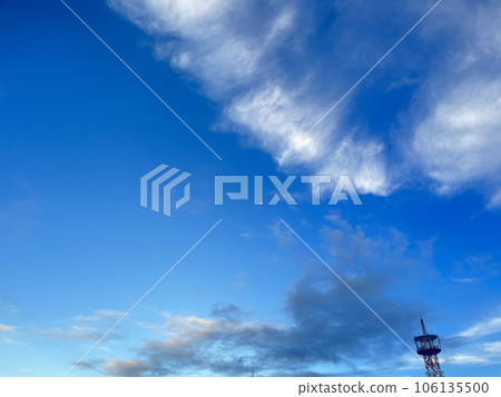 Clouds in the blue sky and an airplane in the distance 106135500