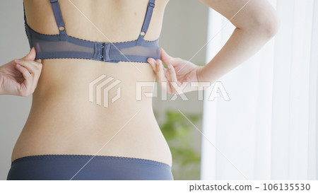 woman hooking her bra woman hooking her bra 106135530