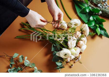 Florist makes a bouquet of mix flowers. 106136368
