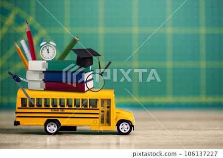 Back to school concept. Yellow school bus with books and variety school supplies over green blackboard. Back to school concept. Yellow school bus with books and variety school supplies over green blackboard. 106137227
