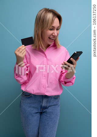 young blond woman with shoulder-length hair dressed in a fashionable pink shirt pays for purchases young blond woman with shoulder-length hair dressed in a fashionable pink shirt pays for purchases 106137250