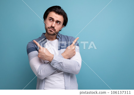 pensive brunette guy in a model appearance dreams on a studio background 106137311