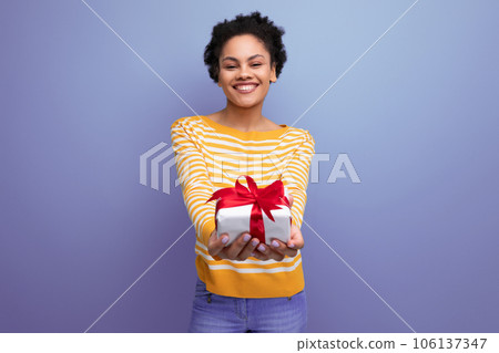 happy afro brunette 20s latin young woman holding out gift box happy afro brunette 20s latin young woman holding out gift box 106137347