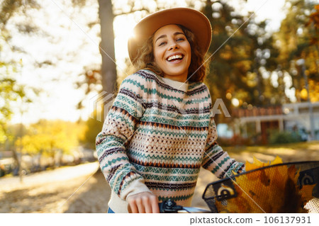 Happy active young woman on bike in autumn park at sunset. Concept of people, recreation, active lifestyle. 106137931