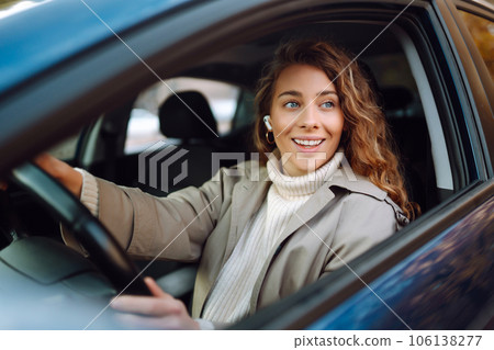 Young woman driving a car in the city. Car sharing, rental service or taxi app. Young woman driving a car in the city. Car sharing, rental service or taxi app. 106138277