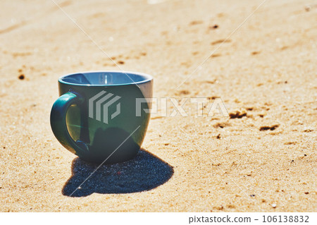 Green ceramic cups for coffee tea beverages on a sunny yellow sand 106138832