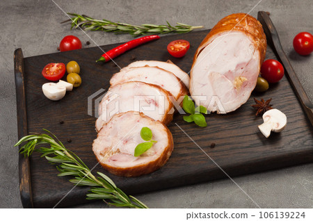 boiled smoked chicken rolls on a dark wooden board 106139224