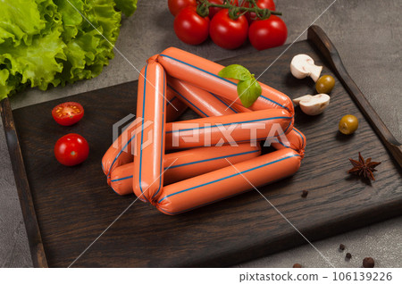 classic meat sausages on a dark wooden background classic meat sausages on a dark wooden background 106139226