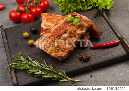 pork ribs boiled and smoked on a dark wooden board pork ribs boiled and smoked on a dark wooden board 106139231