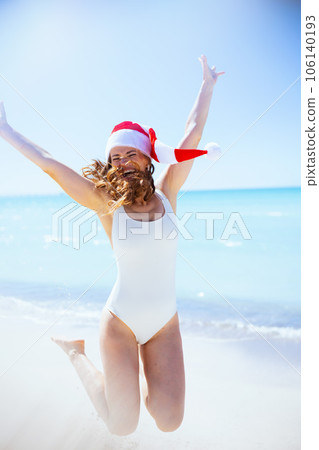 happy modern woman in white beachwear jumping at beach 106140193