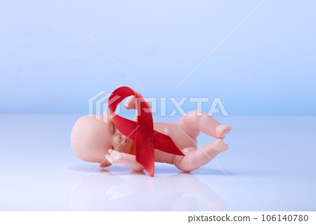 Red awareness ribbon and baby doll, Youth HIV and AIDS Awareness Day Red awareness ribbon and baby doll, Youth HIV and AIDS Awareness Day 106140780