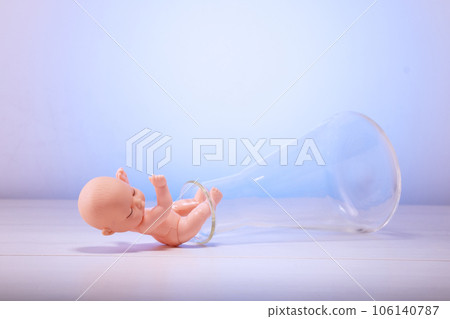 Figurine of a pupa on chemical test tubes. Concept of artificial insemination, test tube baby Figurine of a pupa on chemical test tubes. Concept of artificial insemination, test tube baby 106140787