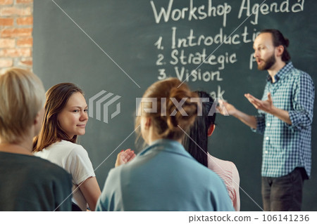Business and entrepreneurship symposium. Speakers giving talk at business briefing. Rear view of unrecognized participant in audience. 106141236