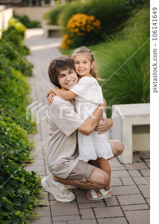 Portrait of happy and beautiful sister with her cousin. Adorable little girl and handsome teenage boy Portrait of happy and beautiful sister with her cousin. Adorable little girl and handsome teenage boy 106141649