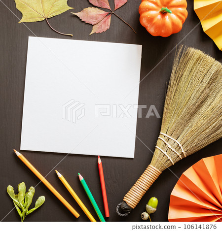 Autumn composition with white sheet of paper, pencils, autumn decorations on a black chalkboard. Art workplace for autumn and halloween creativity. A lesson at an art school dedicated to autumn Autumn composition with white sheet of paper, pencils, autumn decorations on a black chalkboard. Art workplace for autumn and halloween creativity. A lesson at an art school dedicated to autumn 106141876