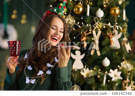 smiling 40 years old woman in living room using smartphone 106142348